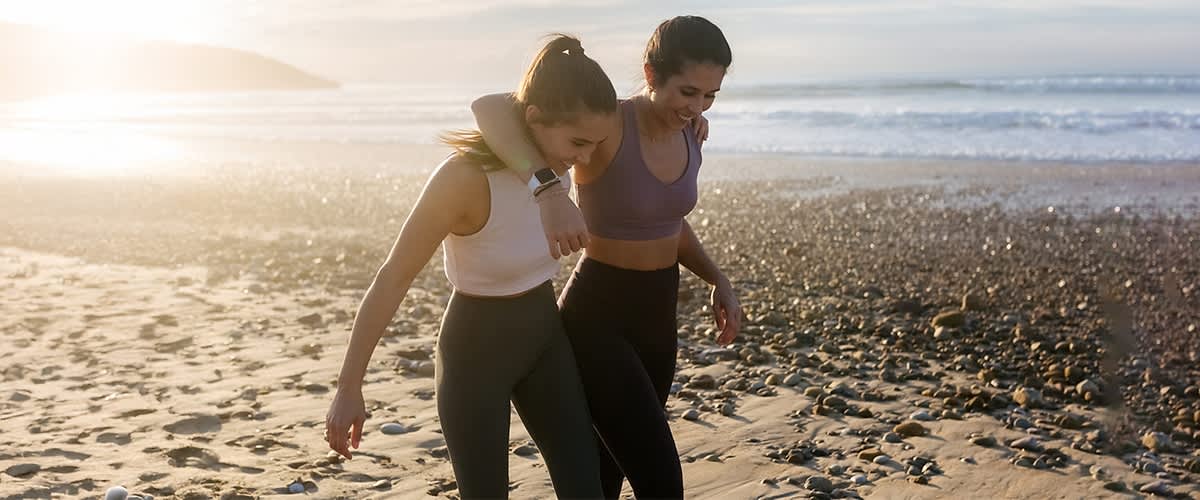 Zwei Frauen Arm in Arm am Strand