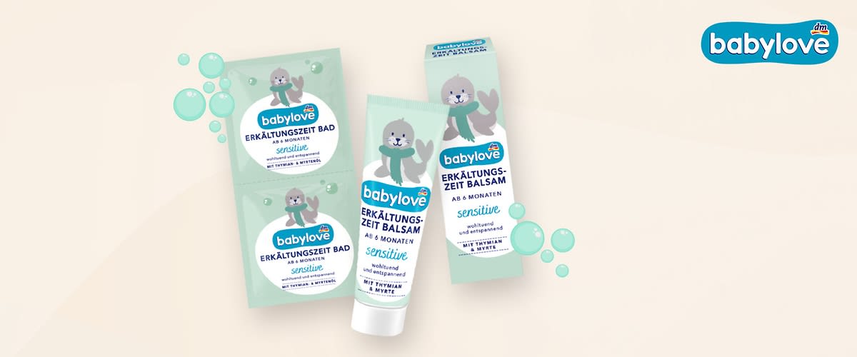 Zwei Babylove Erkältungszeit Bad Sachets und eine Babylove Erkältungszeit Balsam Tube mit der Aufschrift „ab 6 Monaten sensitive“ auf einem hellen Hintergrund mit grünen Blasen und einem Babylove Logo in der Ecke