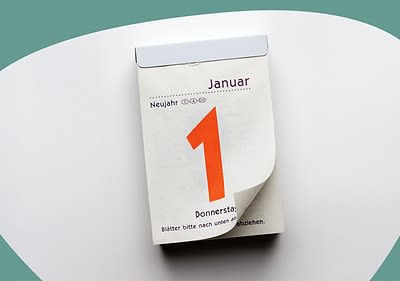 Ein Abreißkalender zeigt den 1. Januar mit der Aufschrift „Neujahr“ und „Donnerstag“ in schwarzer Schrift auf weißem Hintergrund, die Zahl „1“ ist groß und orange