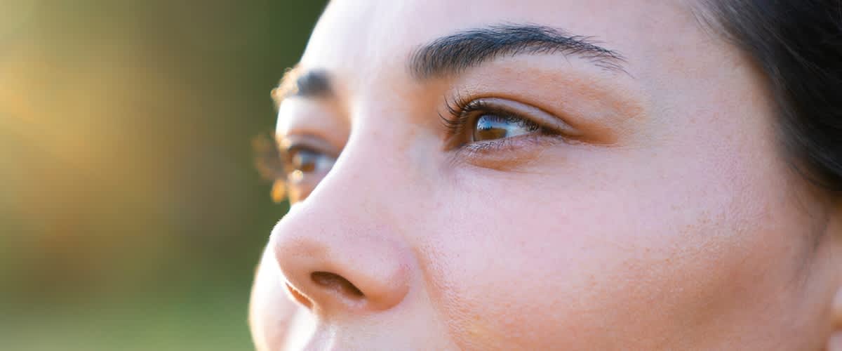 Man sieht die braunen Augen einer Frau in Nahaufnahme.