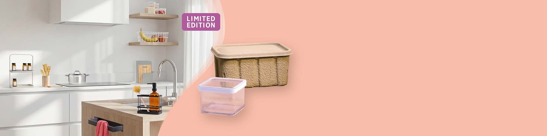 Ein Küchenbereich mit einem modernen Wasserhahn und einer braunen Glasflasche in einem schwarzen Halter. Im Hintergrund ein Korb mit Obst und ein Schneidebrett. Rechts zwei Vorratsbehälter, einer aus braunem Karton und einer aus transparentem Kunststoff mit weißem Deckel. Oben rechts ein lila Schild mit der Aufschrift „Limited Edition“