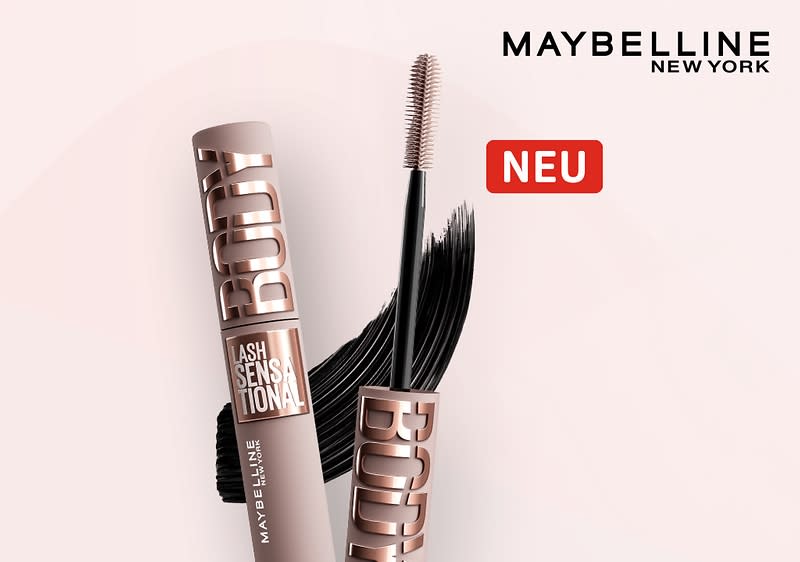 Produktverpackung einer Maybelline Wimperntusche mit der Aufschrift „Lash Sensational“ in Bronze, daneben ein Bürstchen mit schwarzer Farbe, oben rechts das Maybelline New York Logo und ein rotes Rechteck mit dem Wort „NEU“