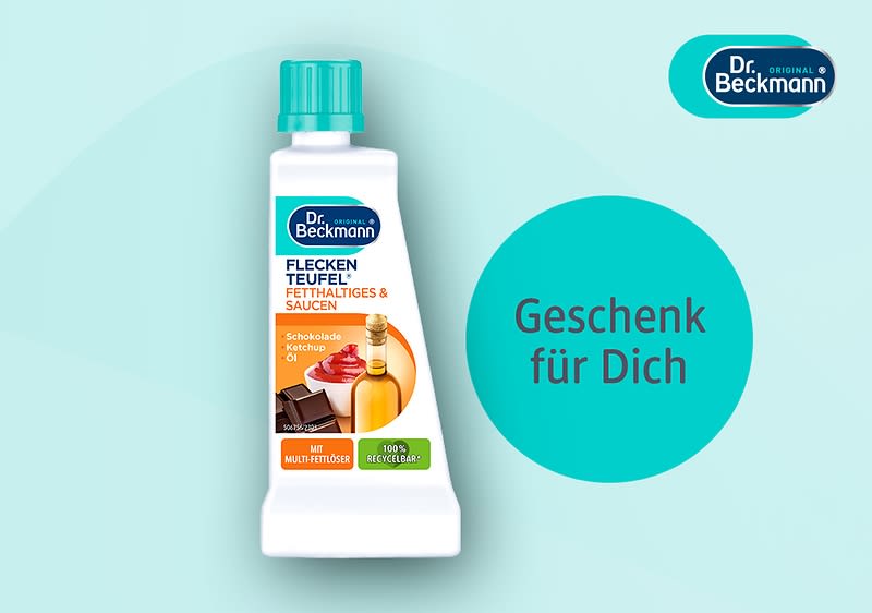 Eine weiße Flasche mit türkisfarbenem Deckel, darauf die Aufschrift „Dr. Beckmann Fleckenteufel Fett, Haltiges & Saucen“ und „Geschenk für Dich“ in einem türkisfarbenen Kreis auf hellblauem Hintergrund