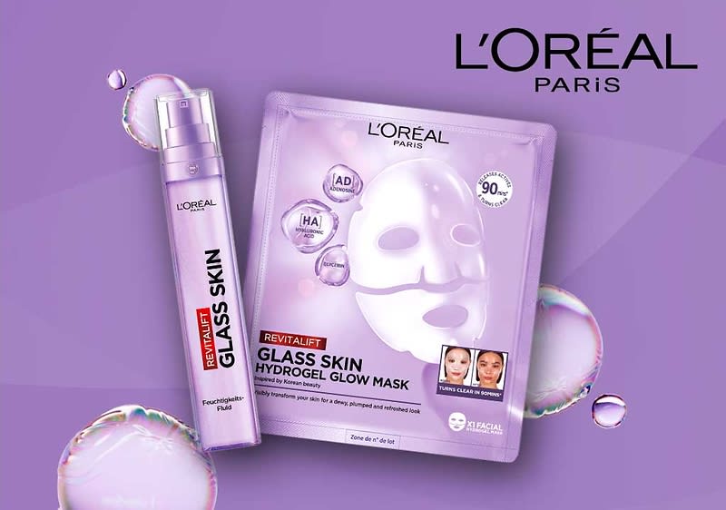 Eine lila Verpackung der L'Oréal Paris Revitalift Glass Skin Hydrogel Glow Mask mit einem Bild einer weißen Maske und der Aufschrift „90% Inhaltsstoffe natürlichen Ursprungs“. Daneben eine lila Flasche mit der Aufschrift „Glass Skin“ und „Revitalift“. Oben rechts das L'Oréal Paris Logo.