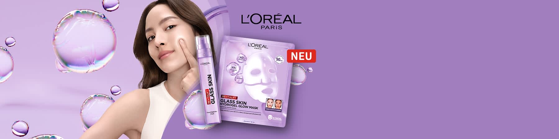 Eine lila Verpackung der L'Oréal Paris Revitalift Glass Skin Hydrogel Glow Mask mit einem Bild einer weißen Maske und der Aufschrift „90% Inhaltsstoffe natürlichen Ursprungs“. Daneben eine lila Flasche mit der Aufschrift „Glass Skin“ und „Revitalift“. Oben rechts das L'Oréal Paris Logo.