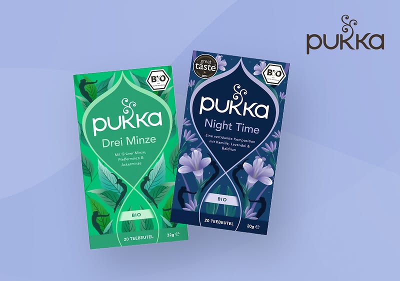 Zwei Pukka-Teepackungen, links grün mit der Aufschrift „Drei Minze“, rechts dunkelblau mit der Aufschrift „Night Time“, beide mit Bio-Siegel und floralem Design