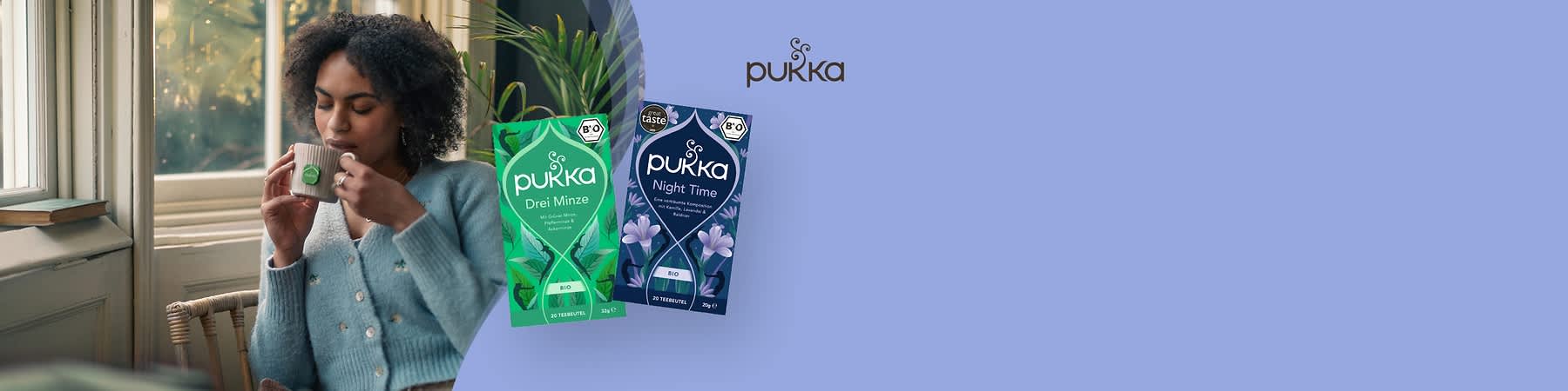 Zwei Pukka-Teepackungen, links grün mit der Aufschrift „Drei Minze“, rechts dunkelblau mit der Aufschrift „Night Time“, beide mit Bio-Siegel und floralem Design