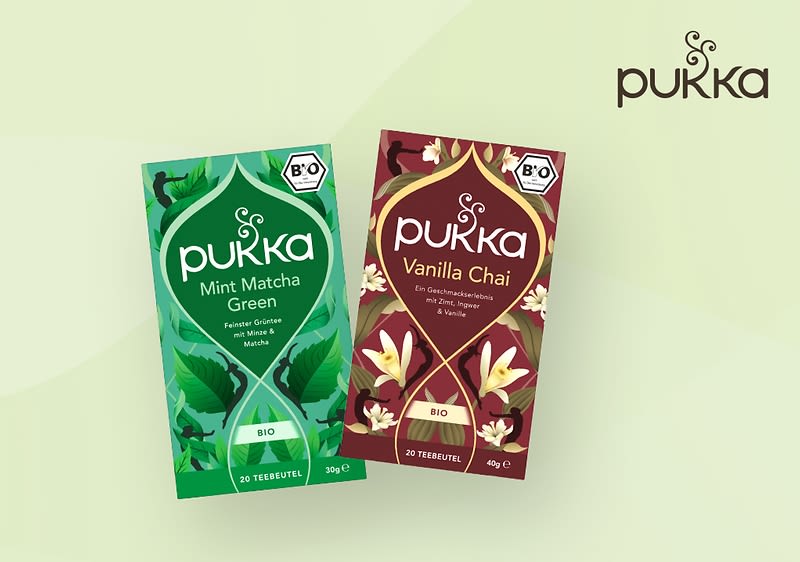 Zwei Pukka-Teeverpackungen auf grünem Hintergrund, links Mint Matcha Green mit grünen Blättern und rechts Vanilla Chai mit Vanilleblüten, beide mit Bio-Siegel