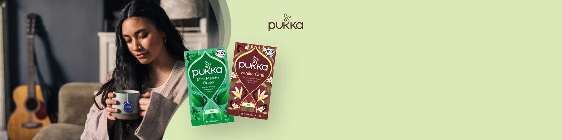 Zwei Pukka-Teeverpackungen auf grünem Hintergrund, links Mint Matcha Green mit grünen Blättern und rechts Vanilla Chai mit Vanilleblüten, beide mit Bio-Siegel
