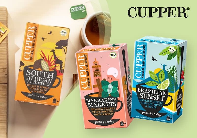 Drei bunte Teepackungen der Marke Cupper mit den Sorten „South African Adventure“, „Brazilian Sunset“ und „Marrakesh Markets“ vor einem grünen Hintergrund