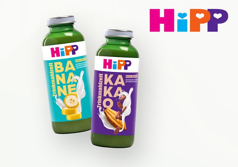 Zwei grüne Flaschen mit Etiketten der Marke HiPP. Die linke Flasche zeigt ein blaues Etikett mit der Aufschrift „Banane“ und einem Bild von Bananenstücken. Die rechte Flasche hat ein lila Etikett mit der Aufschrift „Kakao“ und einem Bild von Kakaobohnen. Links oben das HiPP-Logo.