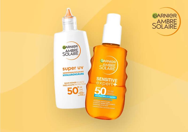 Zwei Sonnenschutzflaschen von Garnier Ambre Solaire, links eine weiße Flasche mit der Aufschrift „Super UV Hyaluronsäure“, rechts eine orange Flasche mit der Aufschrift „Sensitive expert+“ und Lichtschutzfaktor 50.