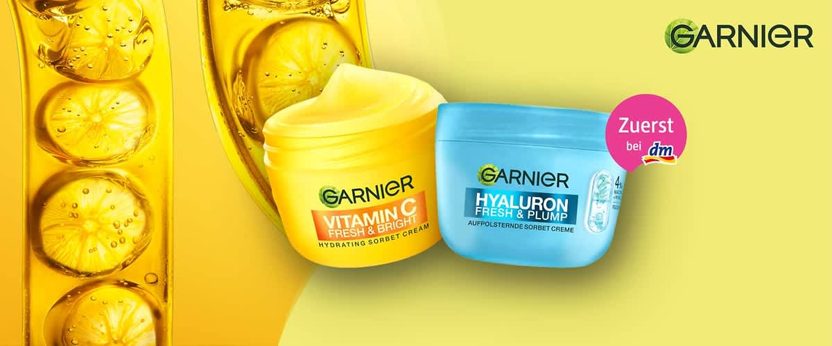 Zwei Cremetiegel von Garnier auf gelbem Hintergrund. Links ein türkisfarbener Tiegel mit der Aufschrift „Salicylic Fresh & Matte Anti-Unreinheiten Sorbet Creme“, rechts ein gelber Tiegel mit der Aufschrift „Vitamin C Fresh & Bright Glow Booster Sorbet Creme“. Oben rechts das Garnier-Logo.