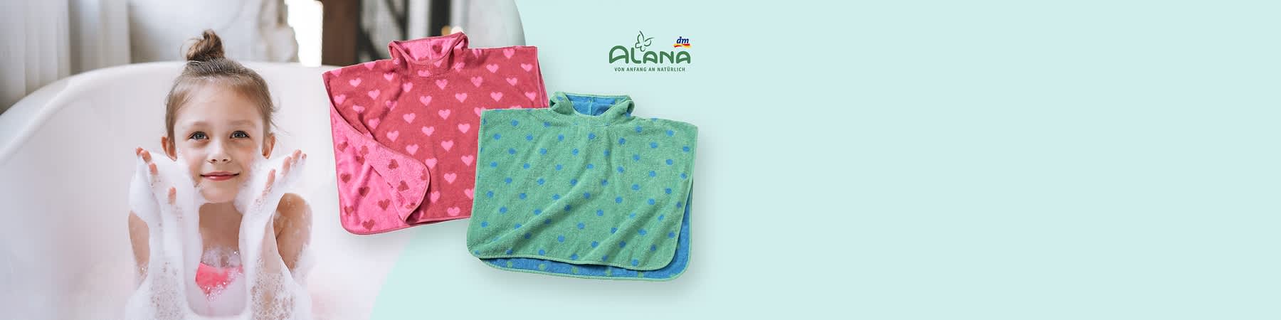 Zwei Kinderponchos, einer in Rosa mit Herzmustern und einer in Grün mit Punkten, daneben das Logo von Alana und dm