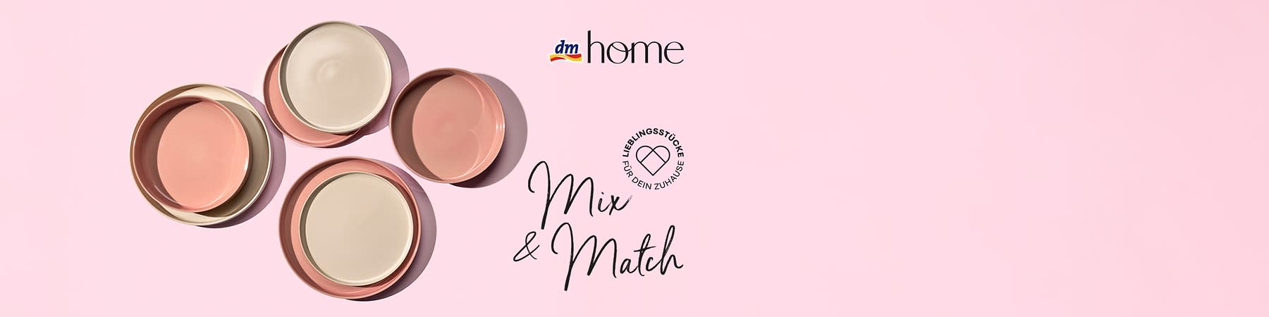 Drei Teller in Rosa und Beige liegen auf einem rosa Hintergrund. Oben rechts das Logo von dm und der Schriftzug „home“. Unten rechts der Text „Mix & Match“ und ein Herzsymbol mit der Aufschrift „Lieblingsstücke für dein Zuhause“