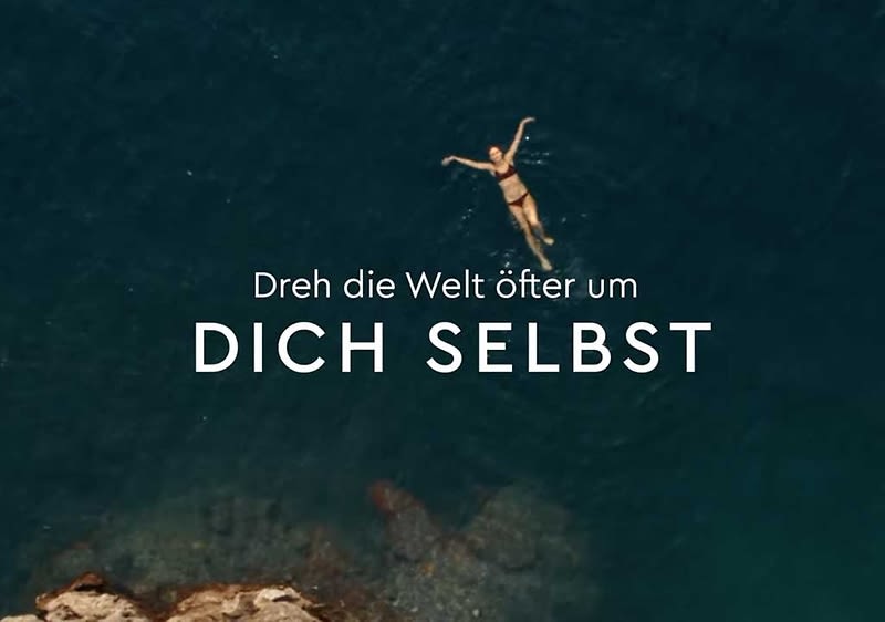 Eine Person schwimmt im Meer, darüber der Text „Dreh die Welt öfter um DICH SELBST“