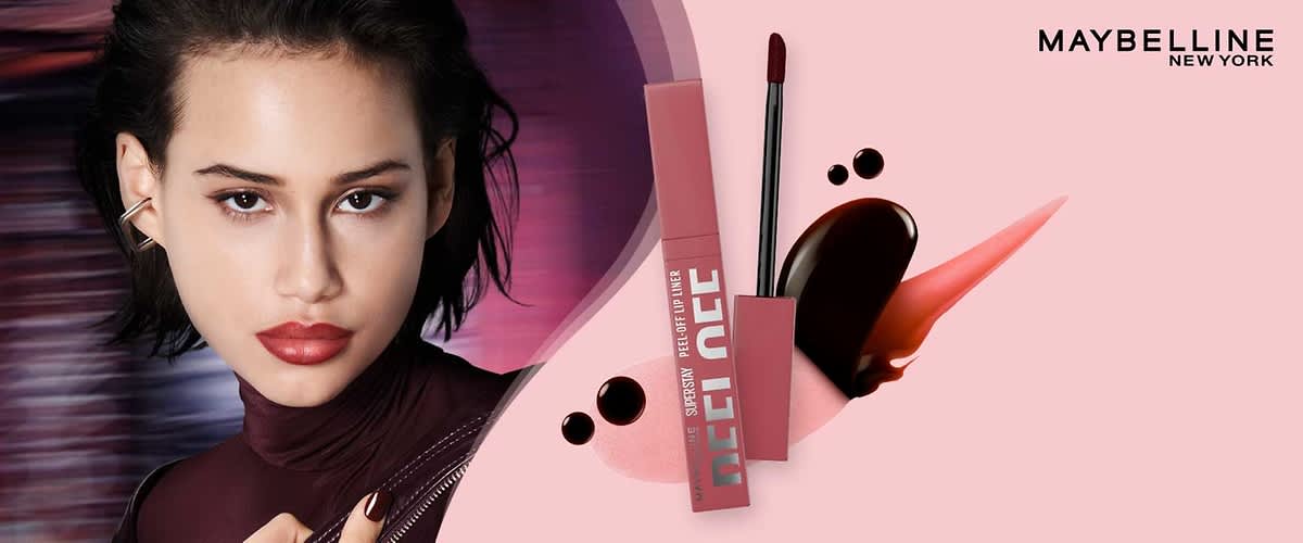 Rosa Verpackung eines Maybelline Superstay Liquid Lipstick mit Applikator und Farbmustern in dunklem Rot und Korallrosa, Markenname „MAYBELLINE NEW YORK“ oben rechts