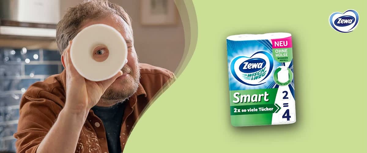 Eine Packung Zewa Wisch & Weg Smart Küchenpapier mit der Aufschrift „2 x so viele Tücher“. Oben rechts steht „NEU“ und „Ohne Hülse weniger Abfall“. Rechts ist das Zewa-Logo.