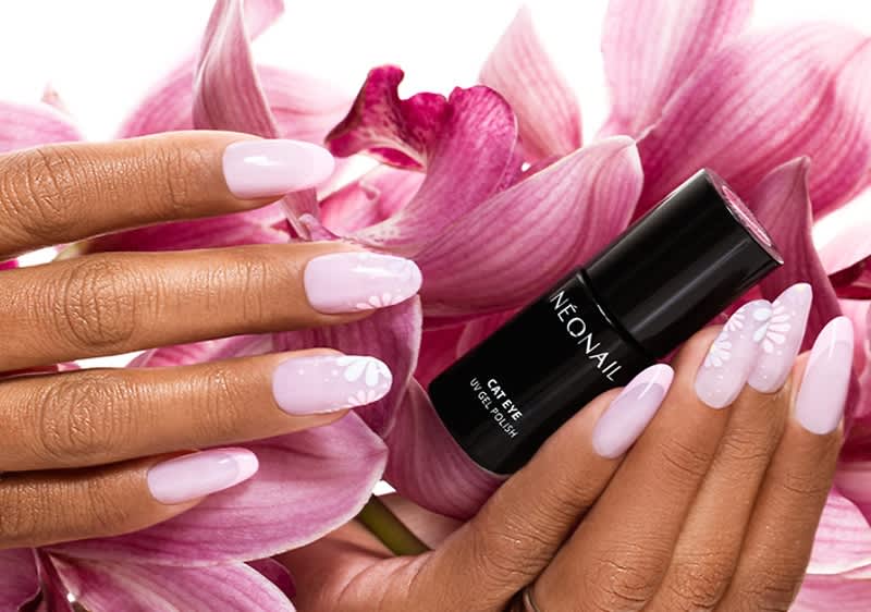 Zwei Hände mit rosa lackierten Nägeln halten eine schwarze Flasche mit der Aufschrift „NEONAIL Cat Eye 9D Gel Polish“ vor einem Hintergrund aus rosa Blüten