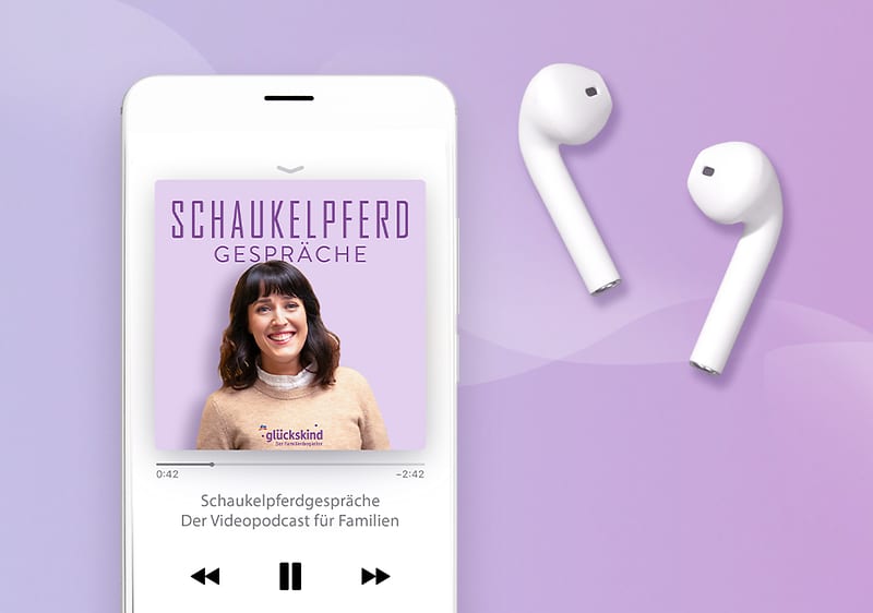 Smartphone mit geöffneter Podcast-Wiedergabe Schaukelpferd Gespräche inklusive verpixeltem Portrait auf violettem Cover, daneben zwei weiße kabellose Ohrhörer auf hellviolettem Hintergrund