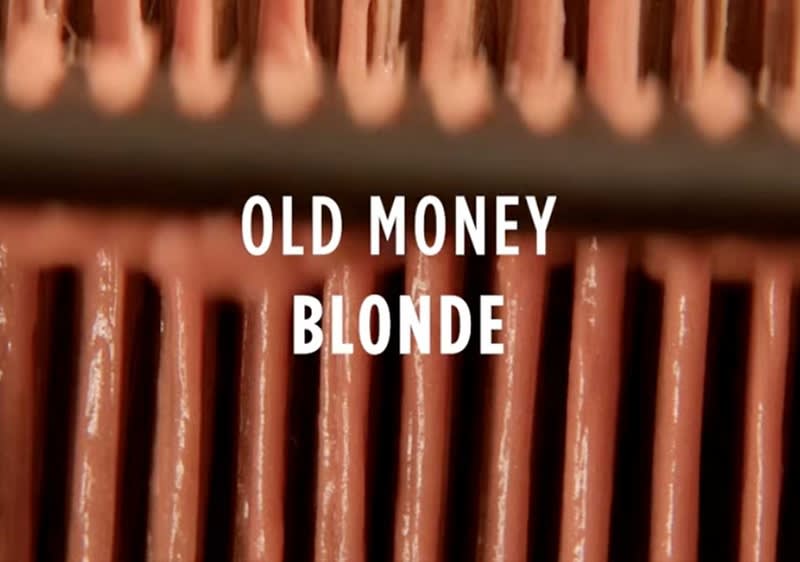 Der Text „Old Money Blonde“ steht vor einem Hintergrund aus vertikalen, rosafarbenen Streifen.
