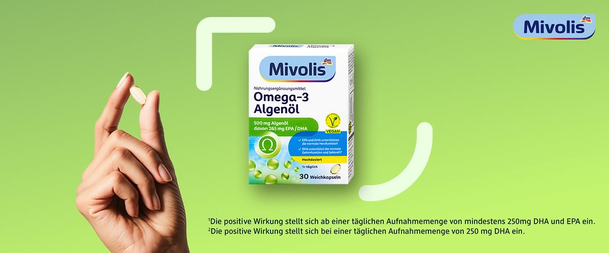 Eine Hand hält eine Weichkapsel vor einer grünen Verpackung von Mivolis Omega-3 Algenöl. Auf der Verpackung steht „Nahrungsergänzungsmittel Omega-3 Algenöl“ mit 500 mg Algenöl, davon 255 mg EPA/DHA. Vegan-Symbol und Hinweis „1x täglich“. Oben rechts das Mivolis-Logo.