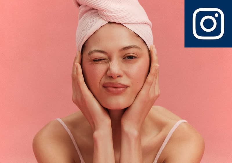 Eine Person mit einem rosa Handtuch um den Kopf hält ihr Gesicht mit beiden Händen. Oben rechts das Instagram-Logo.