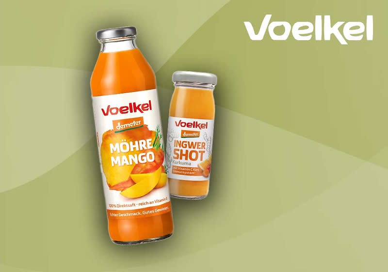 Zwei Flaschen der Marke Voelkel vor grünem Hintergrund. Links eine große Flasche mit der Aufschrift „Möhre Mango“, rechts eine kleinere Flasche mit der Aufschrift „Ingwer Shot“. Beide Flaschen tragen das Demeter-Logo.