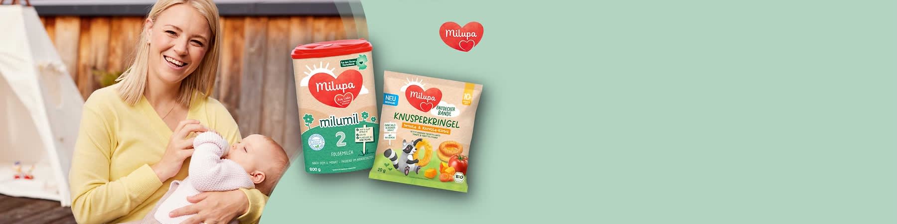Zwei Milupa-Produkte auf hellgrünem Hintergrund: links eine rechteckige Dosierbox mit rotem Deckel und grünem Etikett „Milumil 2 Folgemilch 800 g“, rechts eine beige-grüne Tüte mit rotem Milupa-Logo und Aufschrift „Knusperkringel Aprikose & Pfirsich-Crème“, daneben Abbildung eines kleinen Pandas und Früchteillustrationen