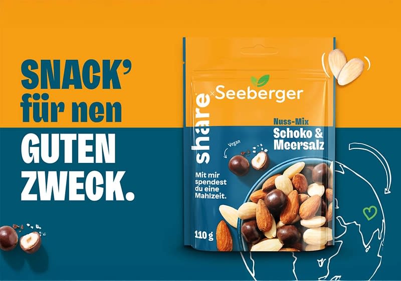 Werbepackung einer 110-g-Tüte Seeberger Share Nuss-Mix Schoko & Meersalz vor orange-blauem Hintergrund, links großer Text SNACK' für nen GUTEN ZWECK, auf der Packung abgebildete Nüsse und Schokolokugeln sowie der Hinweis Mit mir spendest du eine Mahlzeit und ein kleines grünes Blatt-Logo