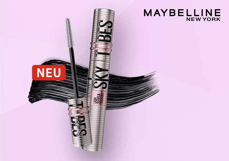 Zwei silberne Maybelline Sky High Mascara-Röhrchen vor hellem rosa Hintergrund, eines geöffnet mit sichtbarer Bürste, schwarzer Mascara-Strich hinter den Produkten und rotes Label „NEU“ neben dem Strich, oben rechts Schriftzug „MAYBELLINE NEW YORK“