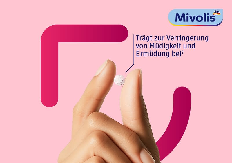 Hand mit zwei Fingern, die eine kleine weiße Tablette zwischen Daumen und Zeigefinger hält; oben rechts blauer Mivolis-Schriftzug und neben der Tablette der Text „Trägt zur Verringerung von Müdigkeit und Ermüdung bei“