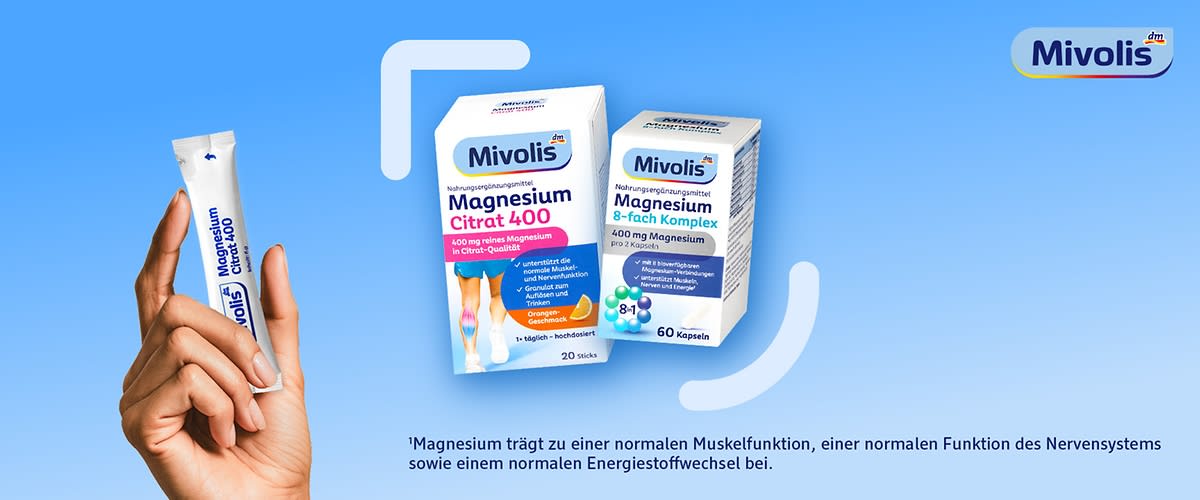 Hand hält einen einzelnen Mivolis Magnesiumstick, daneben eine Mivolis-Box mit der Aufschrift „Magnesium Citrat 400, 400 mg reines Magnesium in Citratsalzen, 20 Sticks“ und ein weißer Mivolis-Vitaminpräparate-Dose mit der Aufschrift „Magnesium Komplex“ vor blauem Hintergrund, oben rechts das Mivolis-Logo