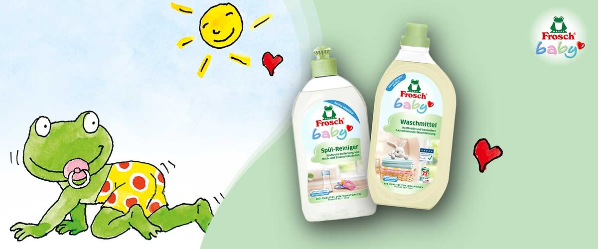 Zwei Frosch Baby Reinigungsprodukte vor hellgrünem Hintergrund: links eine weiße Flasche mit grünem Klappverschluss und Aufschrift „Frosch baby Spül-Reiniger“ mit Babyflaschen-Illustration, rechts eine beige-flaschenförmige Packung mit grünem Schraubverschluss und Aufschrift „Frosch baby Waschmittel“ mit Wäsche- und Plüschtier-Illustration, oben rechts das Frosch-Logo und drei kleine rote Herz-Illustrationen