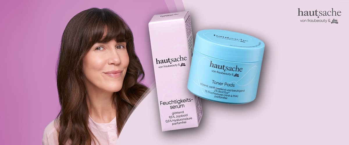 Junge Frau mit braunem, schulterlangen Haar und rosa Bluse im linken Bildbereich; rechts davor ein hellblaues Döschen mit der Aufschrift „hautsache von frauebeauty & dm Toner Pads“ und ein rosafarbenes Verpackungsquader mit der Aufschrift „hautsache Feuchtigkeitsserum“ sowie dem Logo „hautsache von frauebeauty & dm“ auf hellem, zweifarbigem Hintergrund