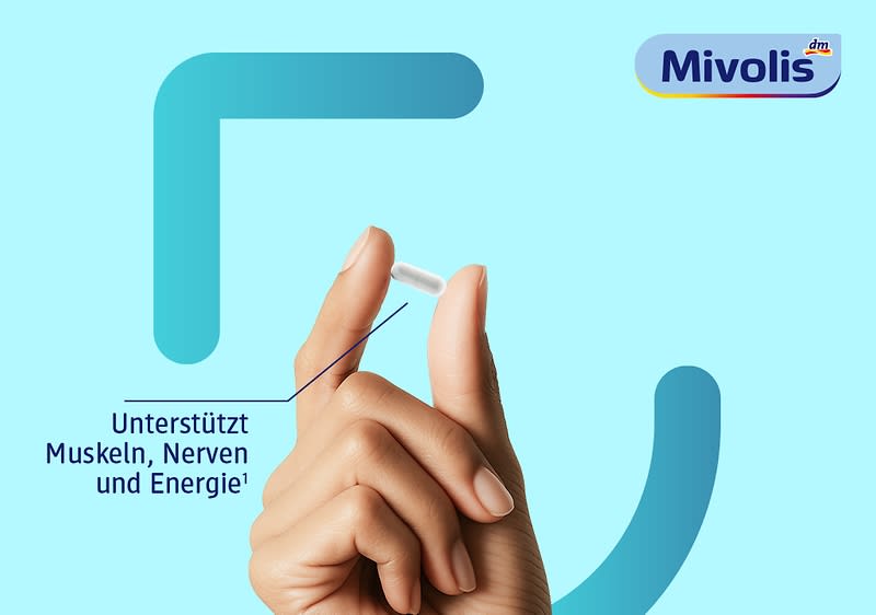 Hand hält zwischen Daumen und Zeigefinger eine kleine weiße Tablette vor hellblauem Hintergrund, links Text „Unterstützt Muskeln, Nerven und Energie“, oben rechts das Logo von Mivolis