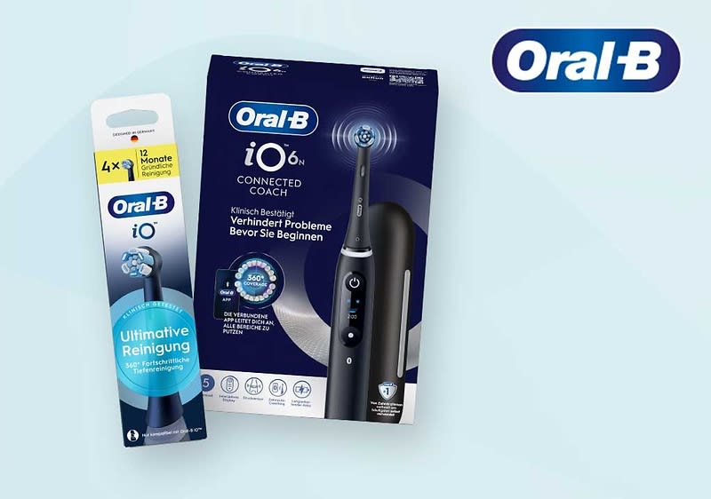 Oral‑B iO6 elektrische Zahnbürste in schwarzem Handstück mit rundem Bürstenkopf neben einer Ersatzbürste in Verpackung, beide Verpackungen dunkelblau mit weißer Aufschrift „Oral‑B iO6 CONNECTED COACH“ und Hinweis „Ultimative Reinigung“, rechts oben das Oral‑B Logo