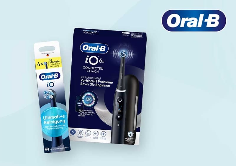 Dunkelblaue elektrische Oral‑B iO6 Zahnbürste mit Ladestation in schwarzer Aufbewahrungs‑Hülle neben einer Packung Oral‑B iO Ersatzbürstenköpfe mit dem Text „Ultimative Reinigung“ auf hellblauem Hintergrund und Oral‑B Logo oben rechts