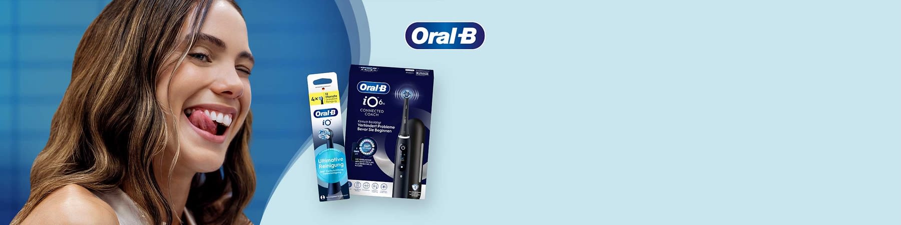 Dunkelblaue elektrische Oral‑B iO6 Zahnbürste mit Ladestation in schwarzer Aufbewahrungs‑Hülle neben einer Packung Oral‑B iO Ersatzbürstenköpfe mit dem Text „Ultimative Reinigung“ auf hellblauem Hintergrund und Oral‑B Logo oben rechts
