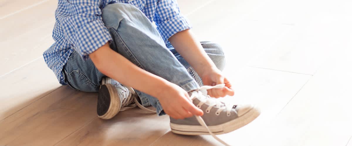 Kind zieht sich selbstständig Schuh an