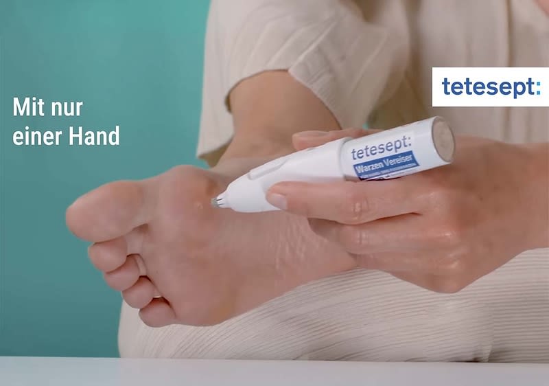 Hand hält ein weißes tetesept Elektronisches Hornhautentferner-Gerät an der Ferse eines Fußes, links Text „Mit nur einer Hand“, rechts oben blaues tetesept-Logo
