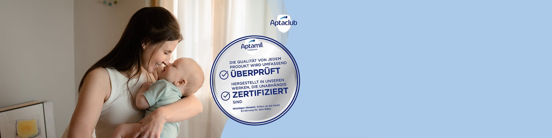 Eine Frau hält ein schlafendes Baby im Arm und streicht ihm mit der Hand sanft über den Rücken, rechts daneben ein blau-weißes Rundlabel mit der Aufschrift „Alle Produkte erfüllen strenge Qualitätsvorgaben“ sowie oben rechts das Aptaclub-Logo