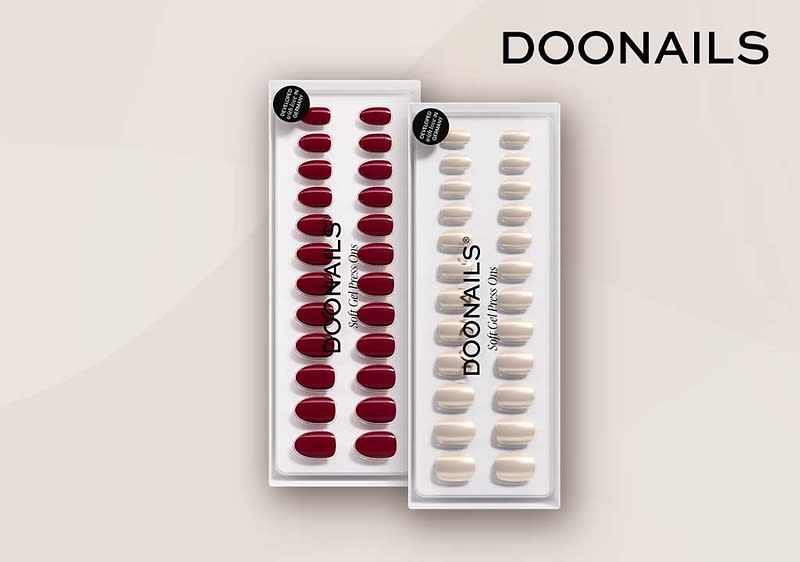 Zwei durchsichtige Plastikblister mit künstlichen Fingernägeln der Marke DOONAILS, links 24 dunkelrote Nägel, rechts 24 beige Nägel, Markenname oben rechts und als Aufdruck auf den Blistern