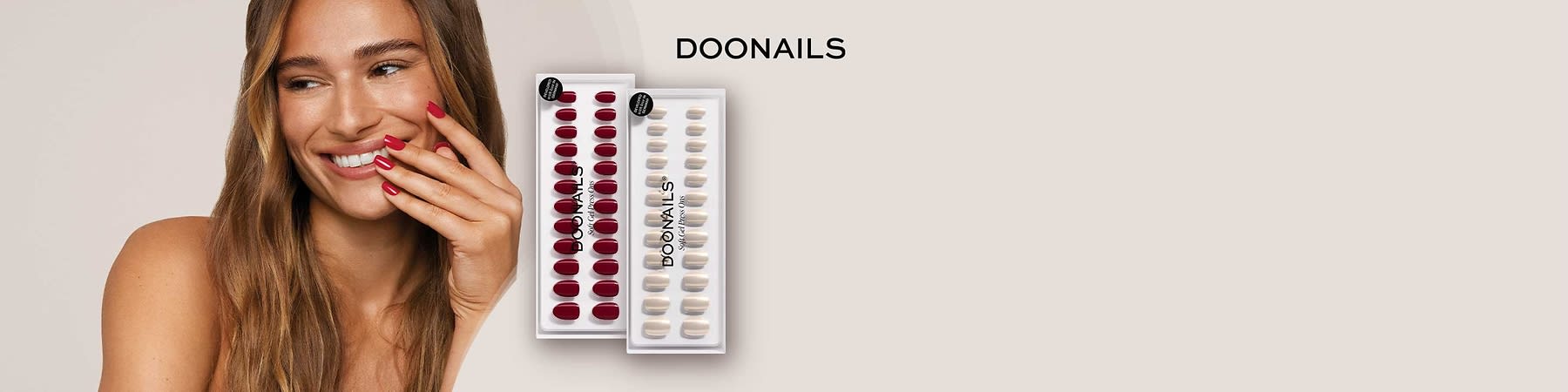 Zwei durchsichtige Plastikblister mit kĂŒnstlichen FingernĂ€geln der Marke DOONAILS, links 24 dunkelrote NĂ€gel, rechts 24 beige NĂ€gel, Markenname oben rechts und als Aufdruck auf den Blistern