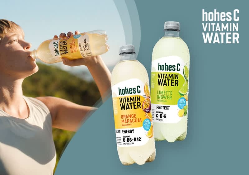 Zwei Flaschen Hohes C Vitamin Water vor einem blauen Hintergrund, die linke Flasche ist mit der Geschmacksrichtung Orange Maracuja und enthält die Vitamine C, B6 und B12, während die rechte Flasche die Geschmacksrichtung Limette Ingwer hat und die Vitamine C, D und E enthält, daneben sind auf der rechten Seite der Schriftzug hohes C Vitamin Water und auf den Flaschen sind die jeweiligen Früchte abgebildet