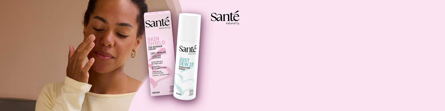 Zwei Sante-Produkte vor rosa Hintergrund: links die rosa Verpackung einer „Skin Shield 24H Barrier Cream“ mit Hinweis „10% Squalan“, rechts eine weiße Pumpspender-Flasche „Just Dew It Hydration Serum“ beide mit Sante-Logo und Angabe „Vegan“ und „0% Alkohol“
