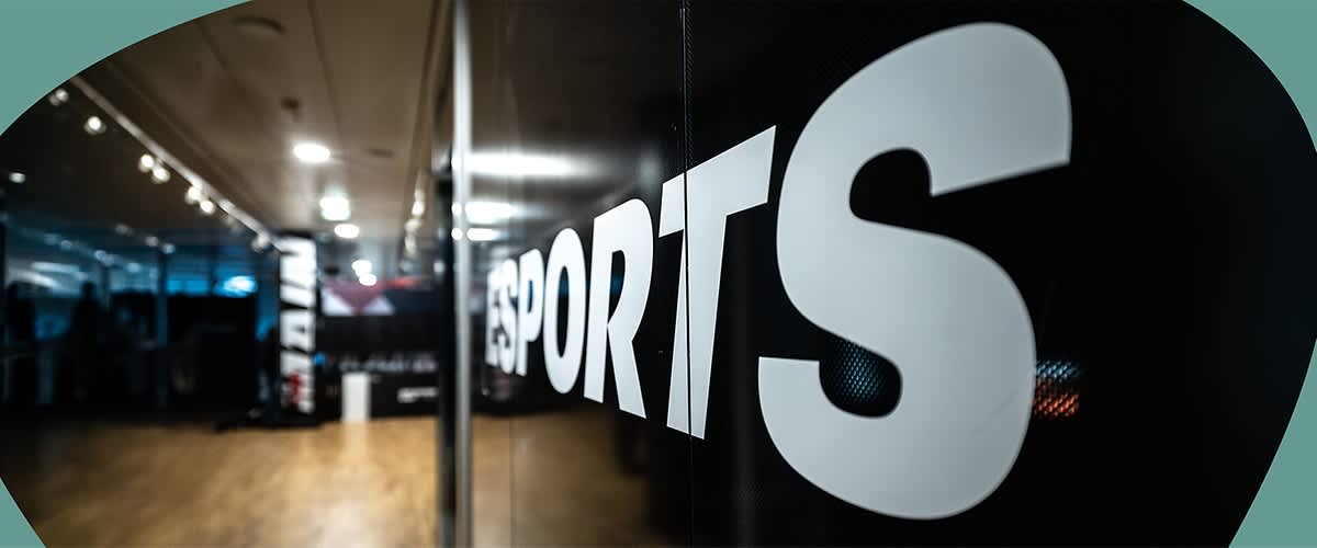 Großaufnahme einer schwarzen Glaswand mit weißem Schriftzug „ESPORTS“