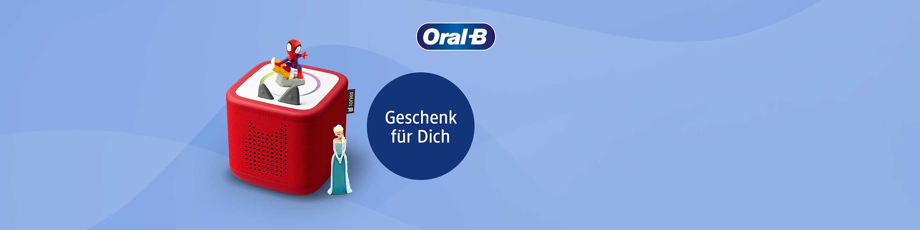 Rotes quadratisches Tonwiedergabegerät mit Figuren von Spider-Man und einer Prinzessin, rechts ein dunkler Kreis mit weißer Schrift „Geschenk für Dich“ und oben rechts das Oral‑B Logo