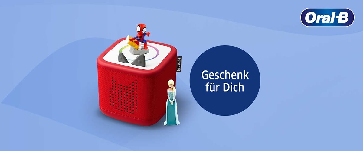Rotes rechteckiges Tonie-ähnliches Hörspielgerät mit Spider-Man-Figur oben und Elsa-Figur an der Seite, daneben blaues Oval mit weißer Aufschrift „Geschenk für Dich“ und Oral‑B-Logo oben rechts