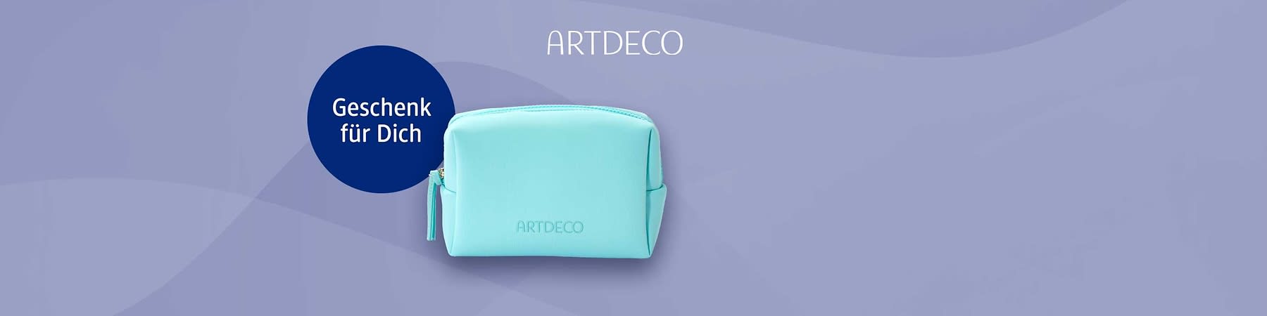 Hellblau-türkises Kosmetiktäschchen mit Reißverschluss und geprägtem Schriftzug „ARTDECO“, links ein dunkelblauer Kreis mit weißer Aufschrift „Geschenk für Dich“, oben rechts Schriftzug „ARTDECO“